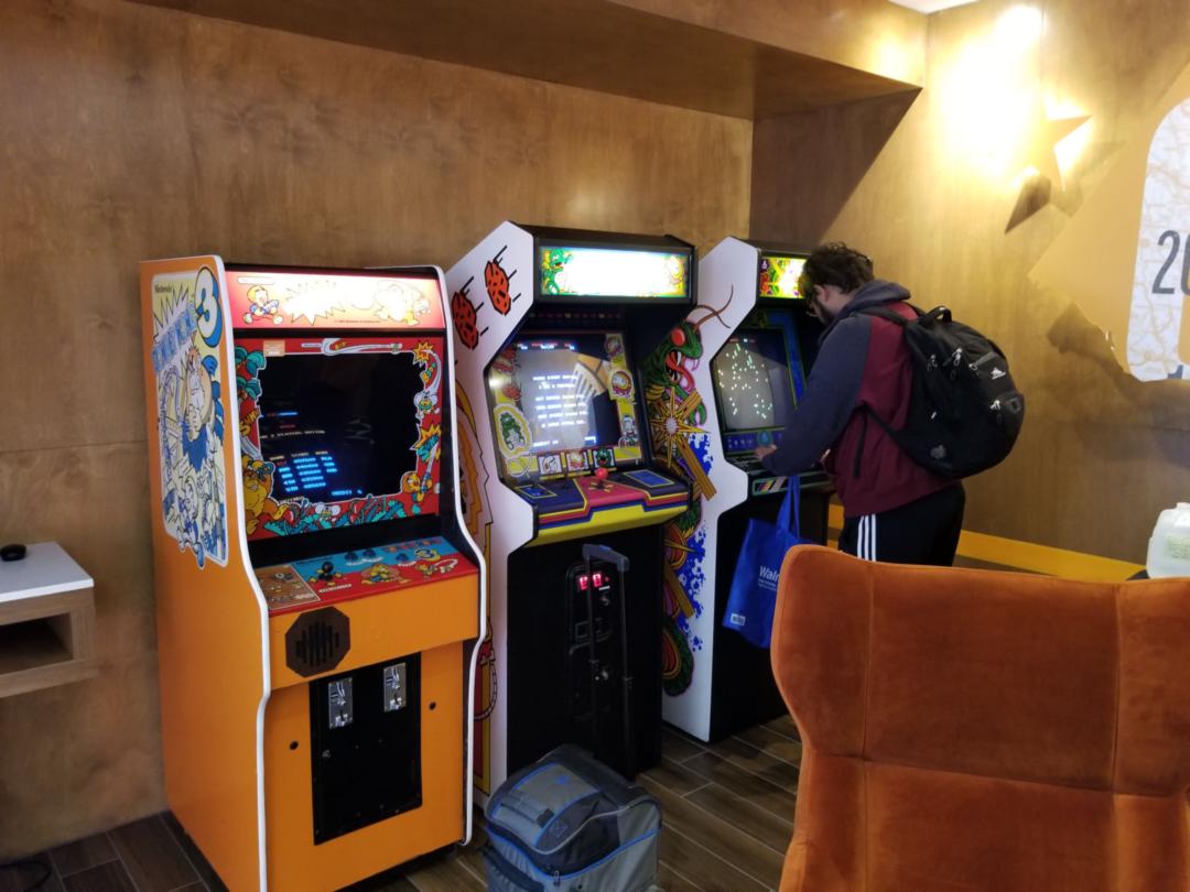 Three arcade cabinets with a token machine to their left