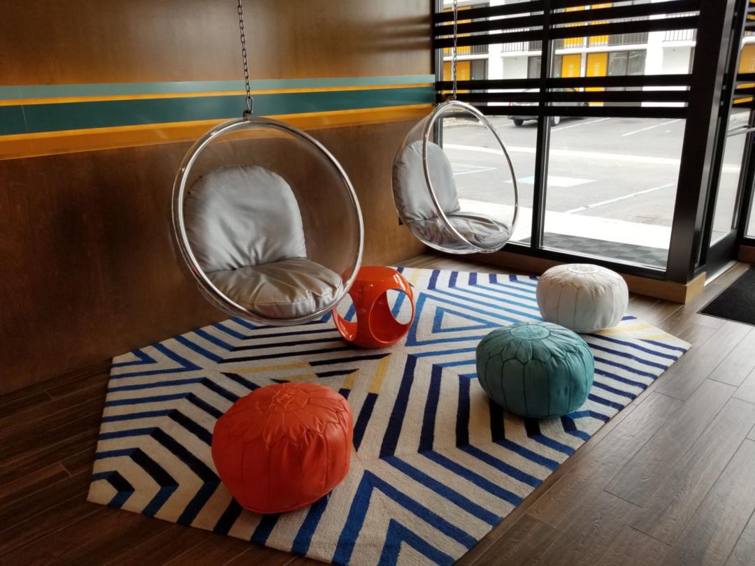 Modern-looking circle chairs surrounded by cloth stools in a hotel lobby